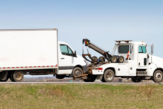 photo of medium duty truck  being towed